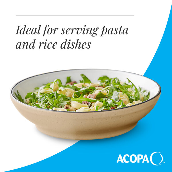 A tan matte stoneware pasta bowl filled with pasta and greens.