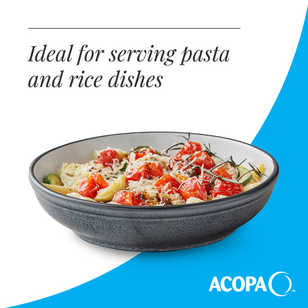 A matte midnight blue stoneware pasta bowl filled with pasta and vegetables.