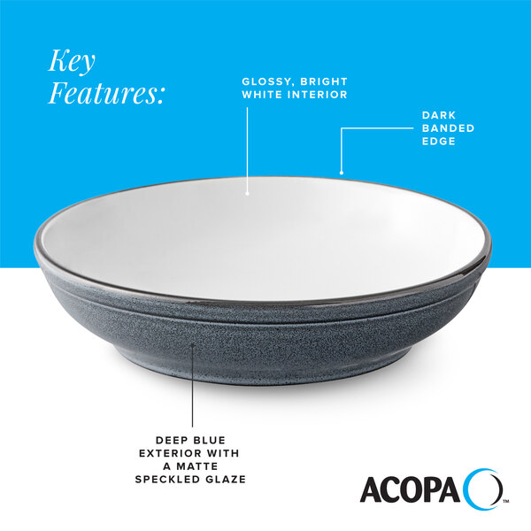 A deep blue matte stoneware pasta bowl with a glossy white interior and dark banded edge.