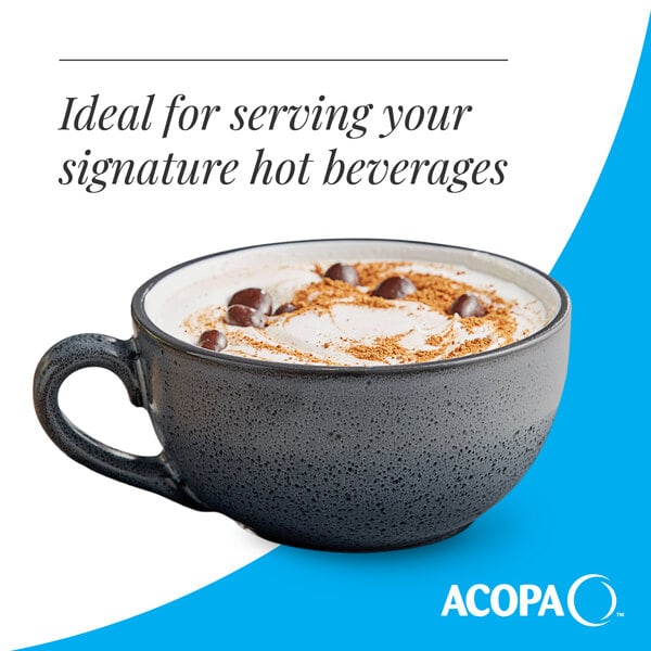 A matte midnight blue stoneware cup with a handle, filled with a hot beverage and topped with whipped cream and chocolate pieces.