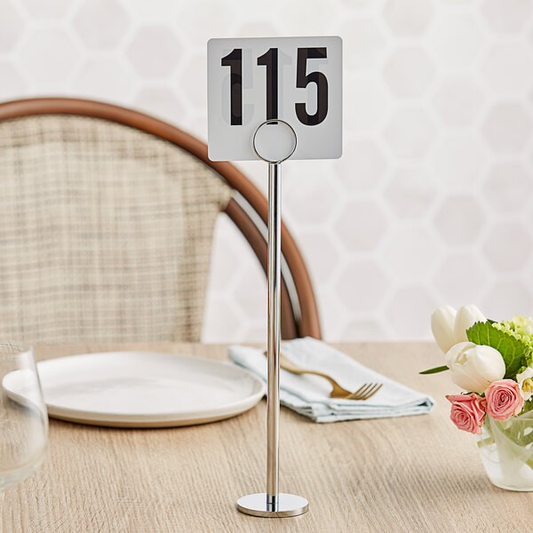 A Tablecraft chrome-plated menu holder with a table number on it.