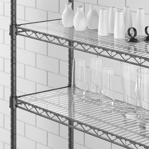 Clear PVC shelf liner on a Regency shelf holding glass cups and vases.