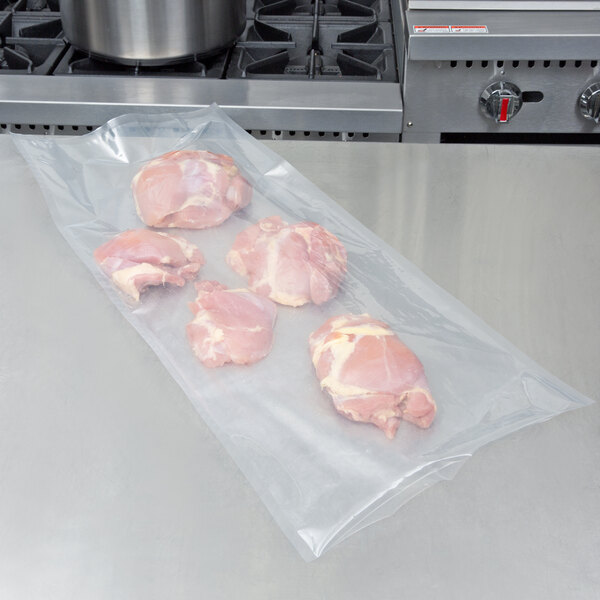 A piece of raw meat on a table with ARY VacMaster vacuum packaging pouches.