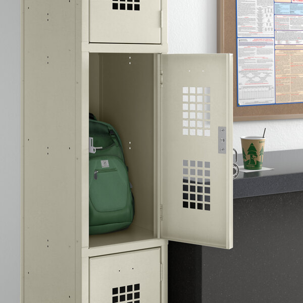 A Regency single tier locker with a green backpack inside.