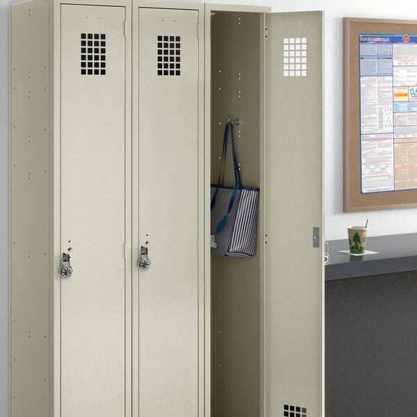 A beige Regency locker with three compartments in a room.