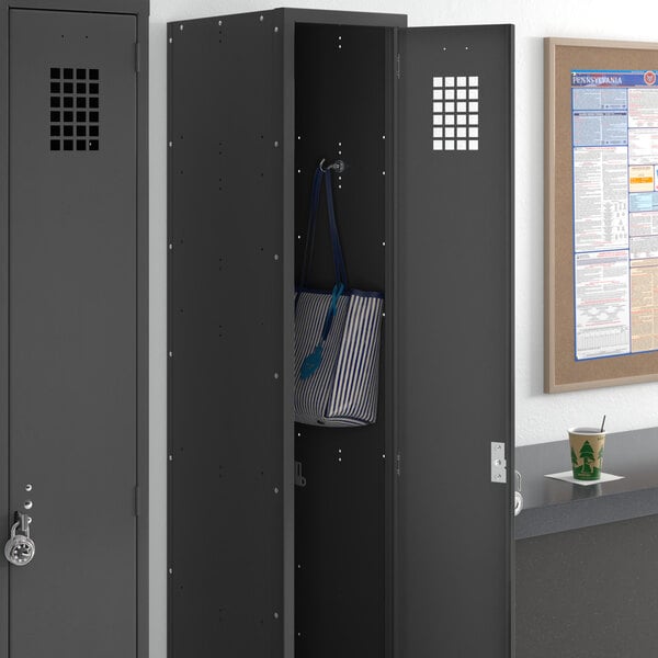A black Regency single tier locker in a corporate office with a blue and white striped bag inside.