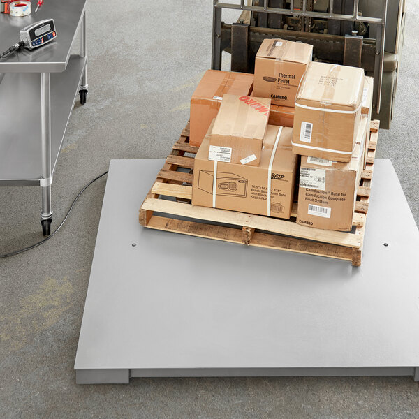 A Tor Rey industrial floor scale with a pallet and boxes on it.