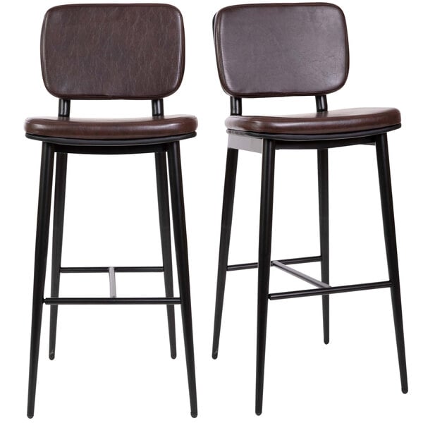 A pair of brown leather barstools with metal legs.