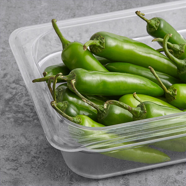 A plastic container of fresh Serrano peppers.