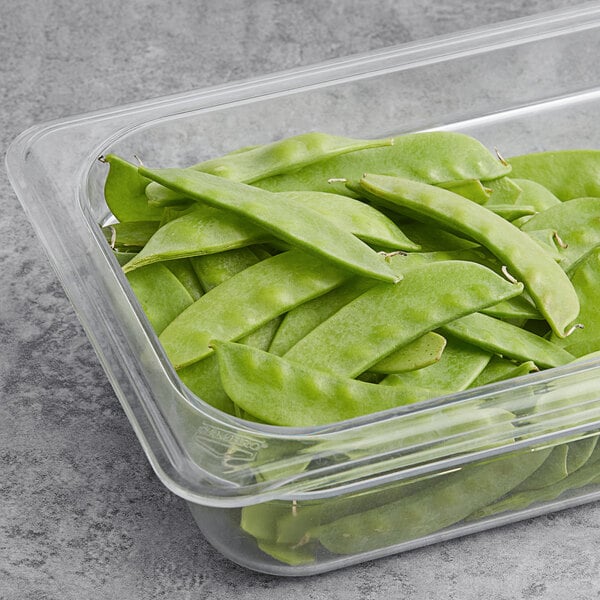 A plastic container filled with fresh snow peas.