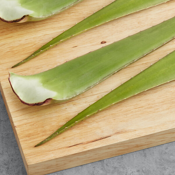 Fresh aloe vera leaves on a cutting board.