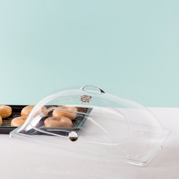A Cal-Mil tray of donuts with a clear dome cover.