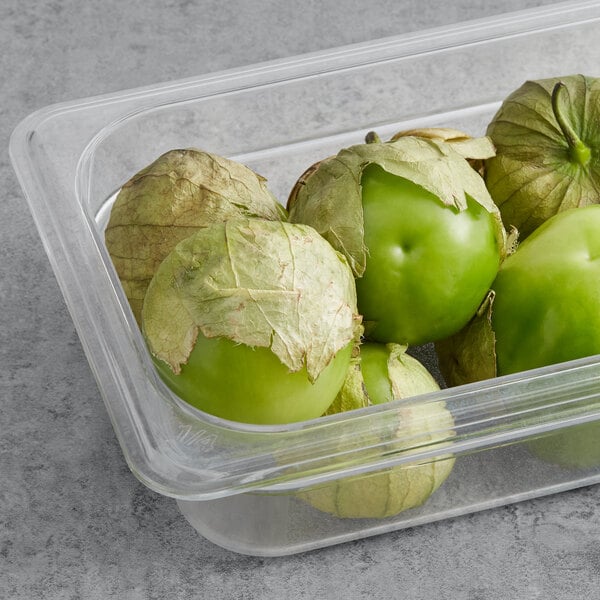 A plastic container with fresh tomatillos in it.