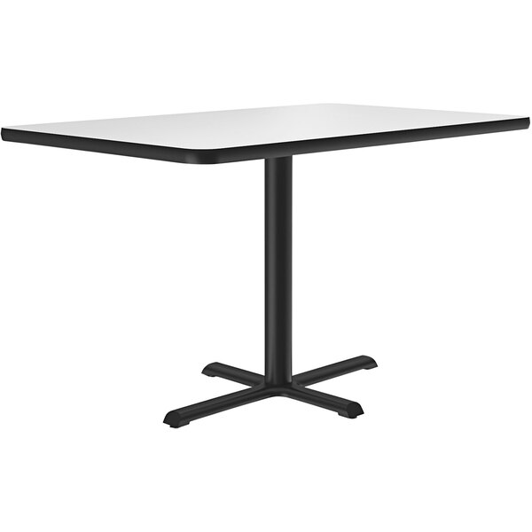A white rectangular table with a white rectangular top and black legs.