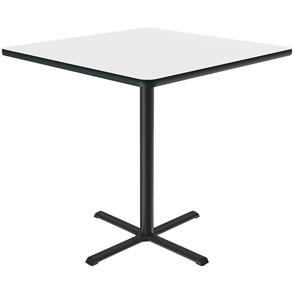 A white square Correll bar height table with a black metal base and a dry erase board top.