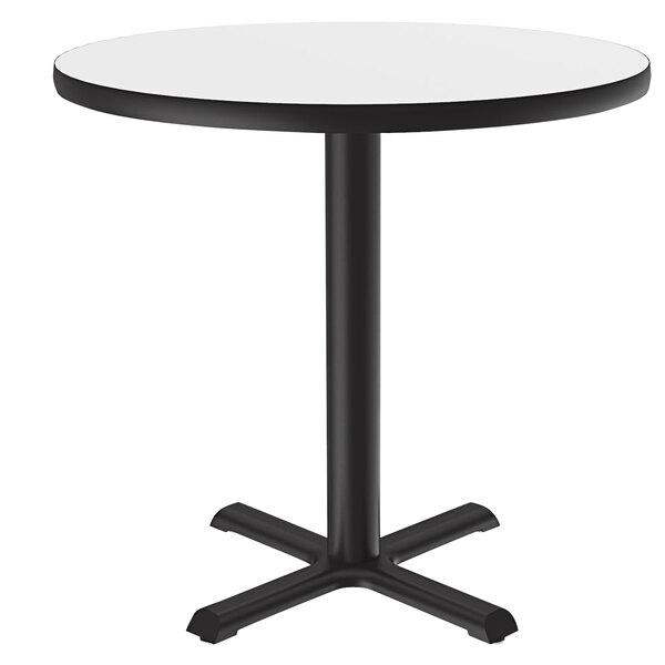 A Correll round white dry erase board table top on a round table with a black base.