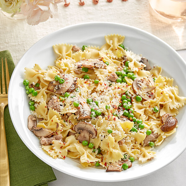 A plate of Barilla Protein+ farfalle pasta with mushrooms and peas.