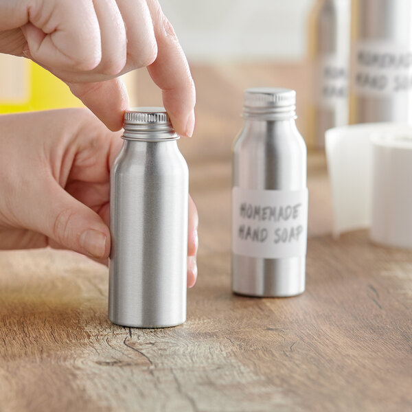 A person's hand opening a silver aluminum bottle.