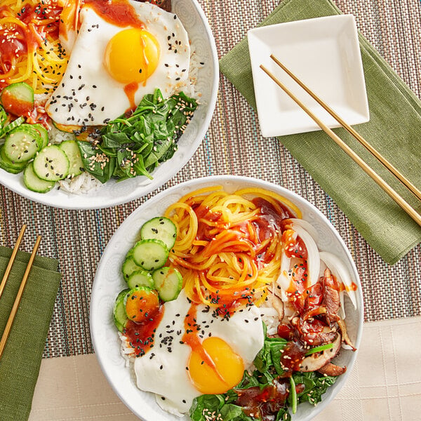 A bowl of food with rice, vegetables, and an egg with Sauce Craft Gochujang Korean Pepper Sauce on a table.