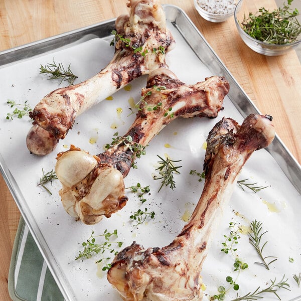 A tray of cooked TenderBison Bison Femur Bones on a table.