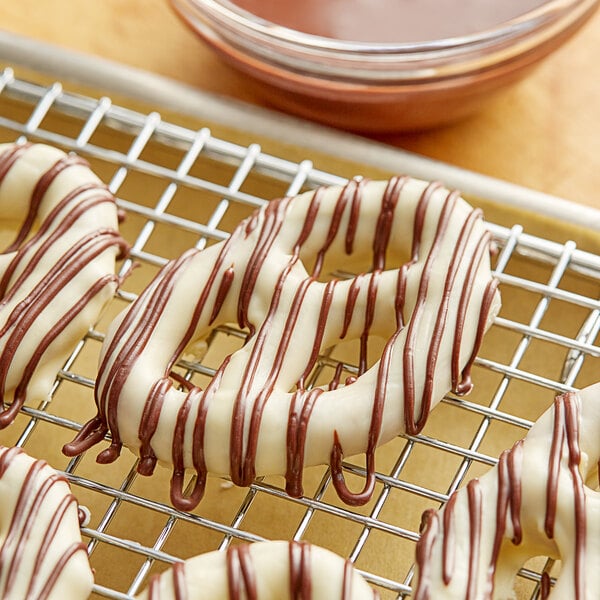 Pretzels with Alpine dark chocolate drizzled on top of them on a cooling rack.