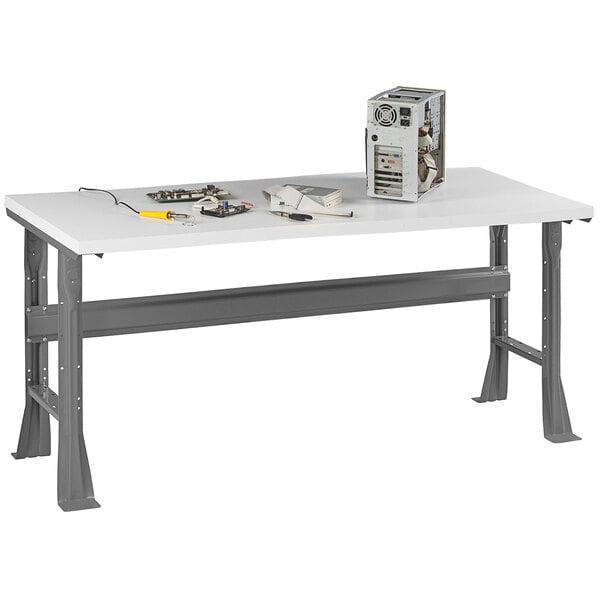 A white Tennsco plastic laminate workbench with flared legs.