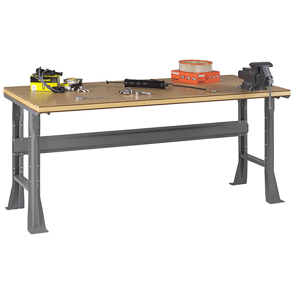 A Tennsco compressed wood workbench with flared legs and tools on top.