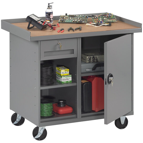 A Tennsco grey steel workbench with a tool cabinet and drawer.