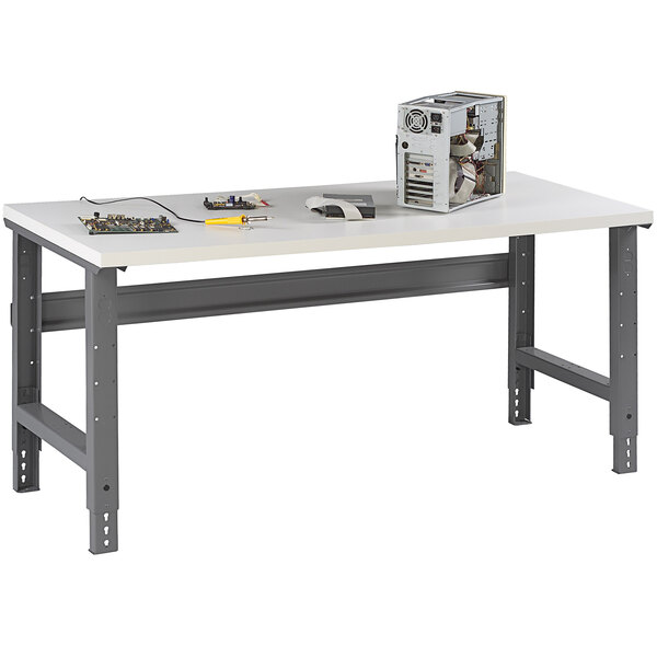 A white Tennsco workbench with a plastic laminate top and adjustable metal legs.