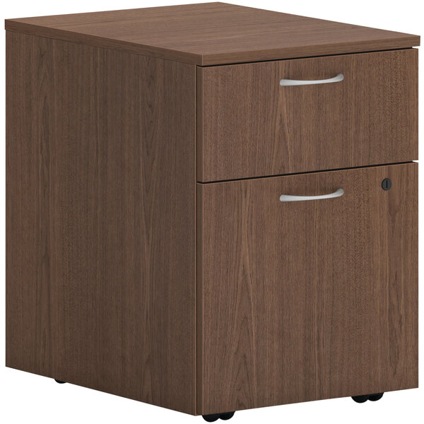 A sepia walnut HON mobile pedestal file cabinet with 1 file drawer and 1 box drawer.