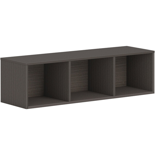 A slate teak wall-mounted open storage cabinet with three shelves.