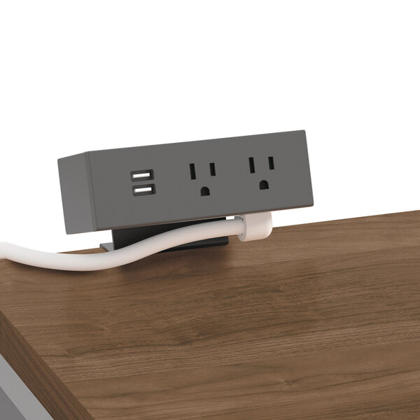 A white and gray HON Snow power strip on a wood table.