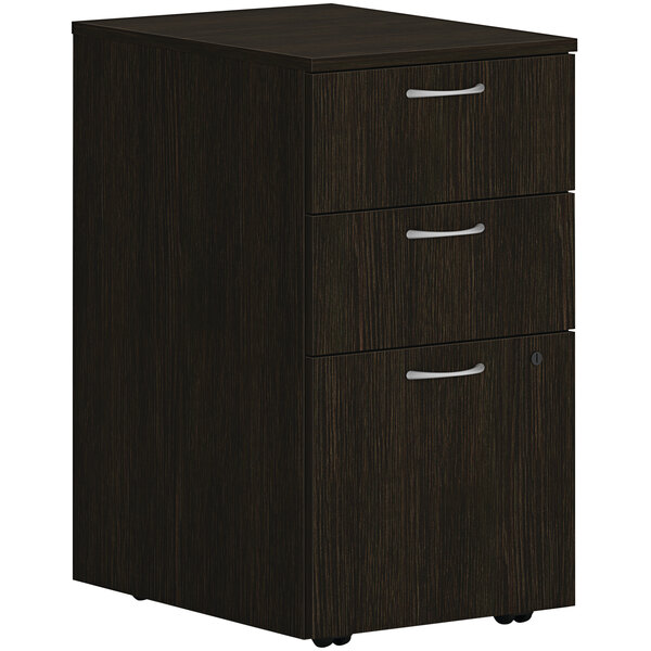 A Java oak mobile pedestal with 2 box drawers and 1 file drawer on wheels with silver handles.