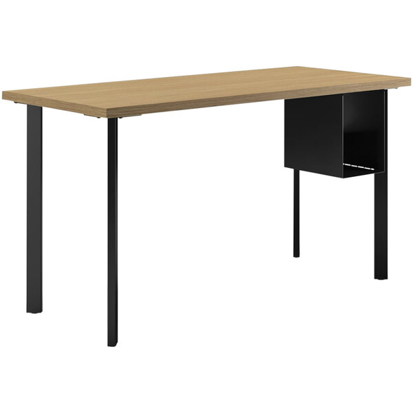 A HON natural recon desk with black legs and a U-storage shelf.