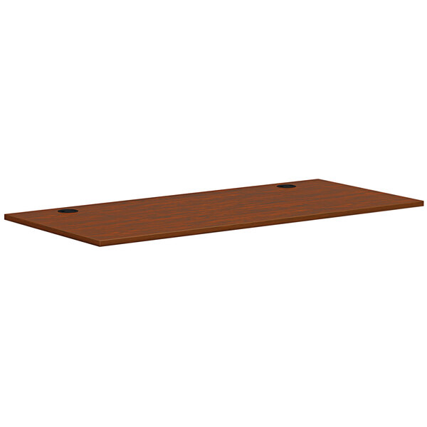 A brown rectangular HON worksurface on a wooden desk.