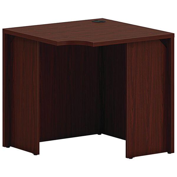 A wooden HON corner desk with a mahogany top.