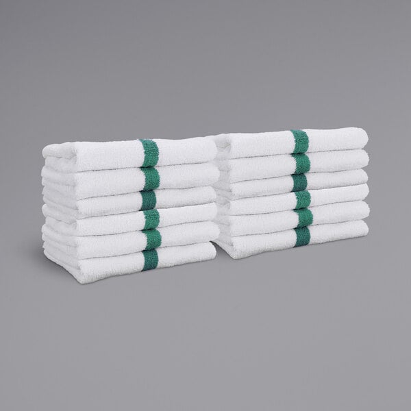 A stack of Monarch Brands white hand towels with green center stripes.