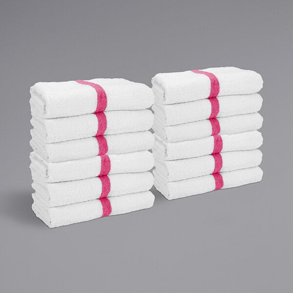 A stack of white towels with a pink center stripe.