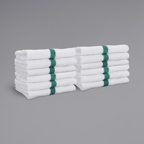 A stack of white Monarch Brands hand towels with green center stripes.
