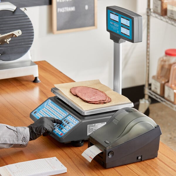 A person using an AvaWeigh digital scale to weigh sliced meat and print a label.