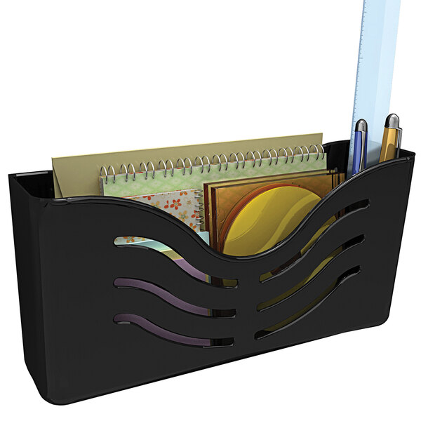 A black Deflecto magnetic wall mount supply organizer holding pens and spiral bound notebooks.