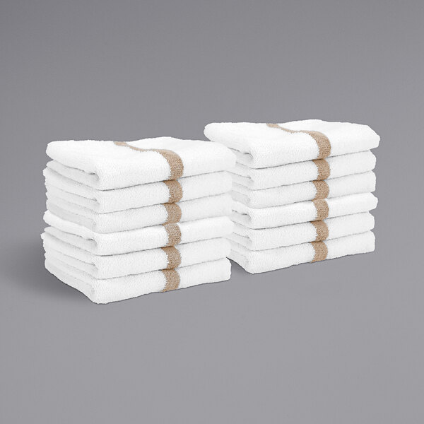 A stack of white towels with beige center stripes.