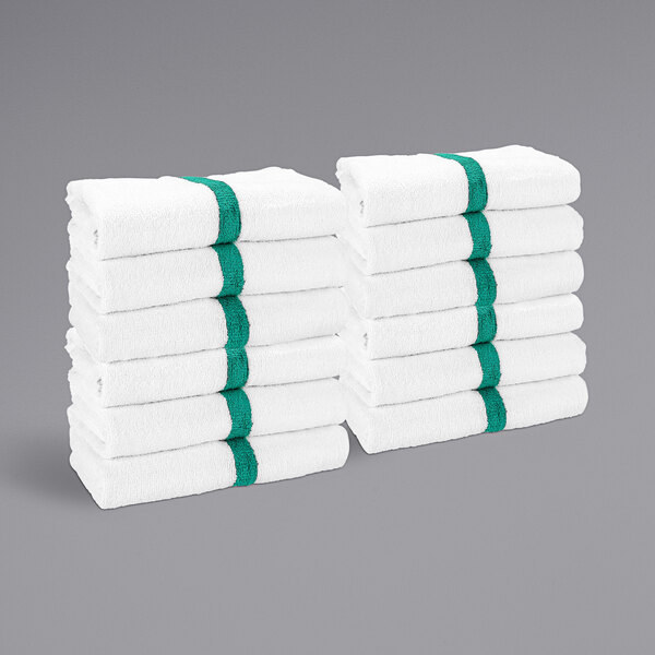 A stack of white towels with green stripes.