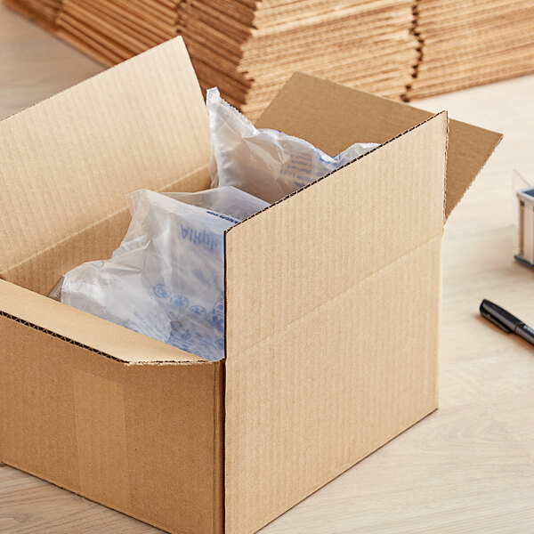 A Lavex Kraft cardboard shipping box with a pen and paper on top of it.
