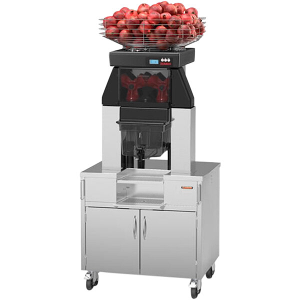 A Zummo commercial juicer with a basket of pomegranates on top.