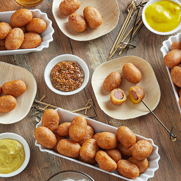 Nathan's Famous beef corn dog nuggets on a table with a bowl of yellow mustard.