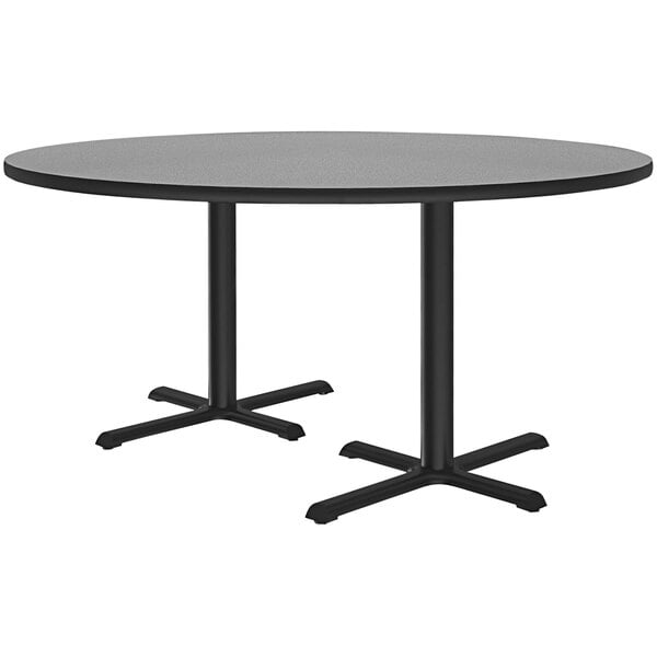 A Correll round gray granite laminate cafe table with two black cross bases.