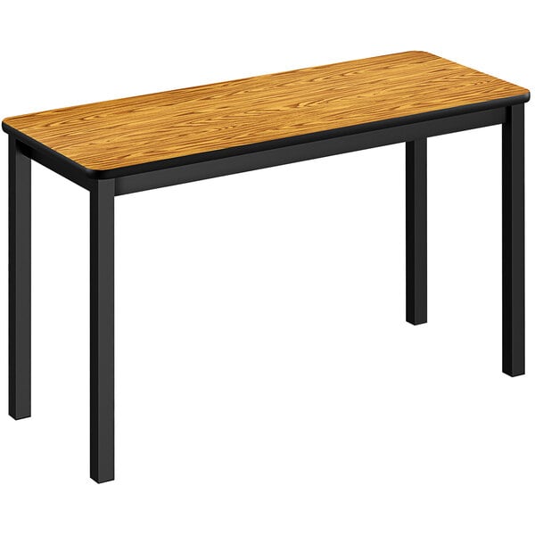 A Correll medium oak rectangular table with black legs.