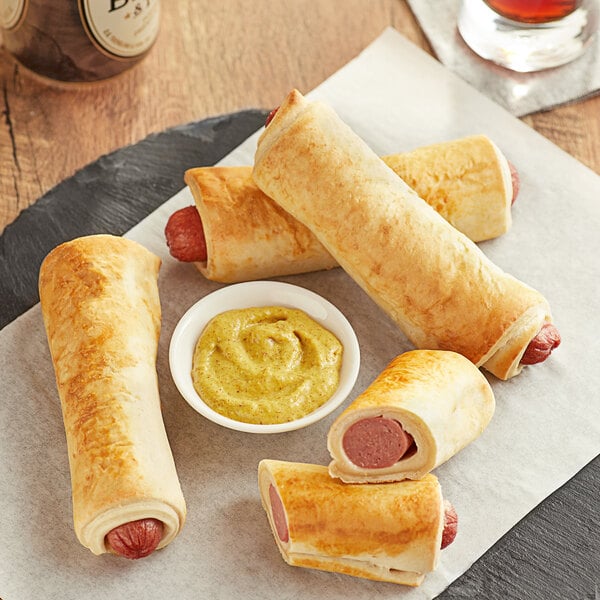 Nathan's Famous beef hot dogs wrapped in pretzel dough with mustard on a plate.