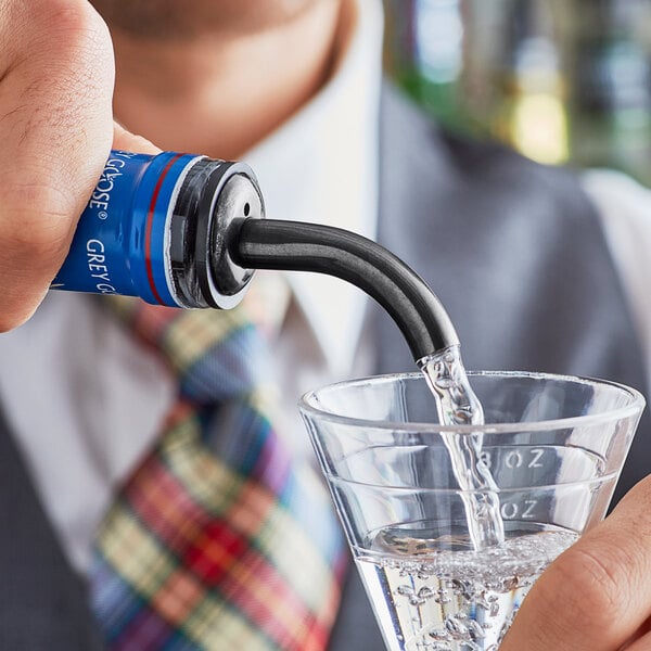 A man using an Acopa Black Angled Liquor Speed Pourer to pour a drink into a glass.